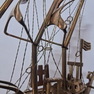 Brass ship showpiece on wooden platform