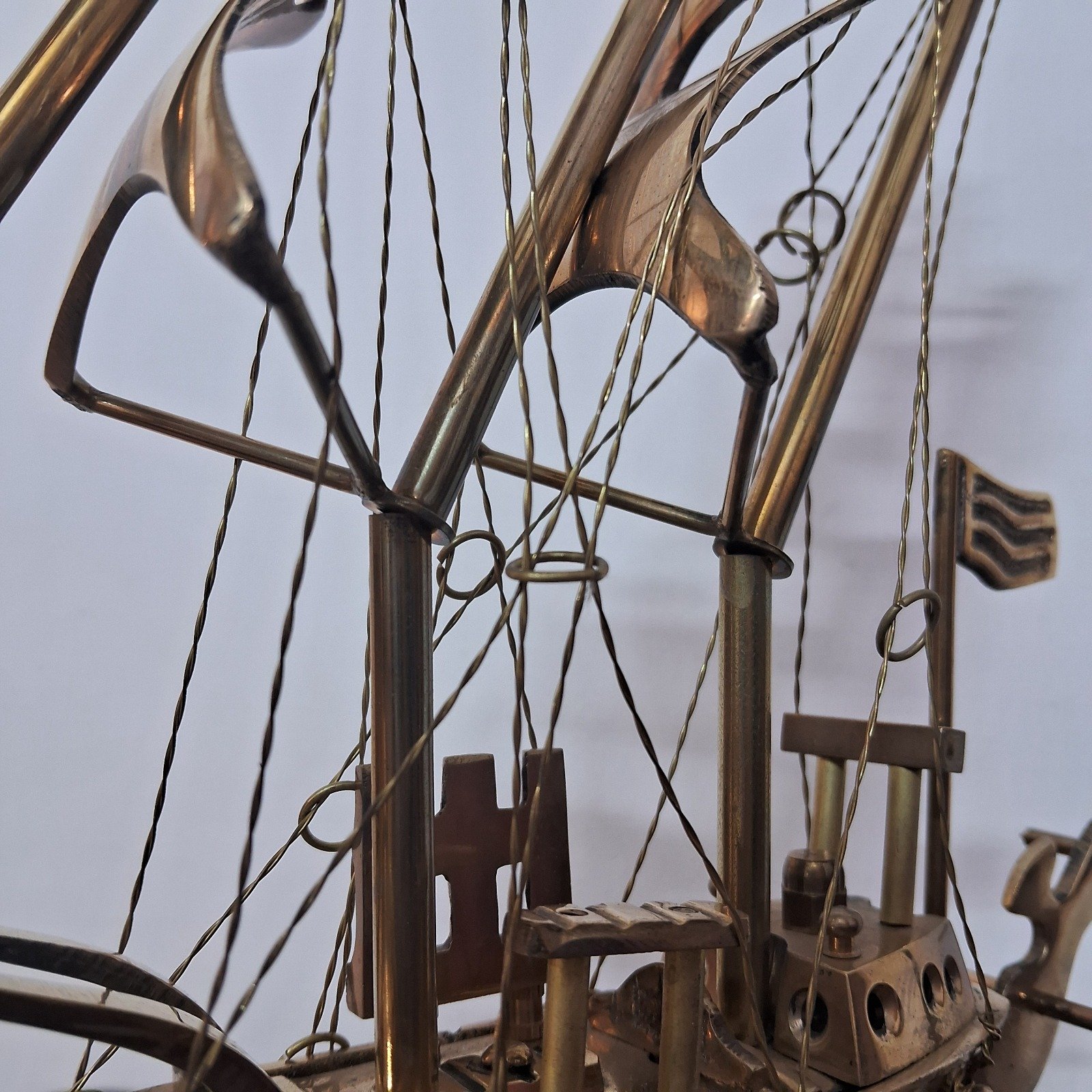 Brass ship showpiece on wooden platform